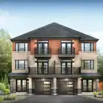 Front exterior of a modern three-story Village Townhome at Empire Avalon with brick cladding, wood-panel accents, and second-story balconies.