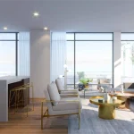 Bright and open-concept suite interior at Distrikt Trailside featuring a contemporary kitchen island, stylish living room seating, and expansive floor-to-ceiling windows.