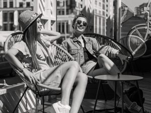 young female students relaxing in the sun - AdobeStock 121021573 e1568757113292 300x225