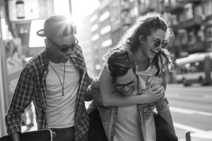 Group of friends hangout at the city street.They embrace each other and laughing.One man carrying female friend on his back. - AdobeStock 293825517 300x200