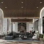 A luxury modern resident lounge at The Greenwich featuring a curved wood-slat ceiling, marble fireplace, and contemporary designer furniture including a grey sectional sofa and white accent chairs.