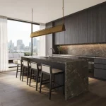 Modern luxury kitchen at The Bedford featuring a large dark marble island with a breakfast bar, integrated high-end appliances, minimalist dark wood cabinetry, and a walk-out balcony with city views.