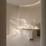 The elegant lobby at The Bedford featuring a sculptural stone concierge desk, neutral textured walls, a patterned marble floor, and minimalist branding.
