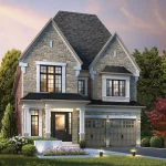 Exterior view of a classic stone-clad luxury home at King's Calling featuring a prominent gabled roof, black-framed windows, and a landscaped front entrance with evening accent lighting.