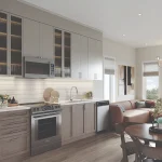 Modern kitchen and living area at Arbor West Brampton showcasing stainless steel appliances, custom cabinetry, hardwood flooring, and a cozy dining nook in an airy, sunlit layout.