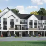 A row of white farmhouse-style Village Homes in Hawthorne East Village showcasing vertical board-and-batten siding, spacious balconies, and integrated garages.