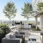 Luxury rooftop terrace at The Rebecca Condos featuring outdoor grilling stations, long dining tables, lounge seating with plush pillows, and manicured greenery overlooking the Hamilton city skyline.