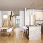 Bright open-concept kitchen and dining area in a Whitby Meadows home, featuring white cabinetry, a marble-patterned island, stainless steel appliances, and light hardwood flooring.
