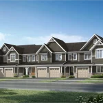 A row of 2-storey townhomes at Wildflowers by Mattamy Homes, showcasing dark siding, white trim gable roofs, stone skirt accents, and individual front-facing garages.