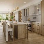 Modern open-concept luxury kitchen interior at The Winston Collection featuring light wood cabinetry, a large waterfall island with seating, high-end appliances, and matching hardwood flooring.