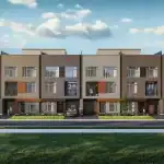 Modern three-story exterior of the Townhomes of Little Rouge, showcasing a contemporary architectural design with brown brick, grey siding, wood accents, and large glass windows under a blue sky.