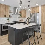 Modern open-concept kitchen interior in an Aster community home, featuring a dark grey island with breakfast bar seating, light wood cabinetry, white subway tile backsplash, and stainless steel appliances.