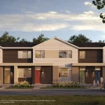 Street-level view of East Hills Crossing Rear Lane Townhomes featuring colorful entry doors, large windows, and landscaped front yards in a walkable community setting.