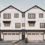 Architectural facade rendering of the Jade townhome series at Marquis Meadows, highlighting three-story white board-and-batten townhouses with integrated two-car garages and elegant dark trim.