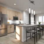 Modern open-concept kitchen at Poppy at Rangeview Auburn floor plan with light wood cabinetry, stainless steel appliances, a large white island with seating, and contemporary pendant lighting.