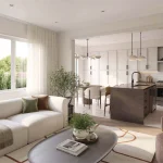 Open-concept living room and kitchen interior at Wellwood featuring a beige sofa, dark island, and dining area with modern light fixtures.