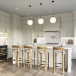 Modern open-concept kitchen interior at The Valley Woodbridge featuring white cabinetry, a large marble island with wood stools, and globe pendant lighting.