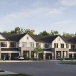 Exterior view of modern multi-family townhomes featuring light stone, board and batten siding, and garages at the Cornerstone community.