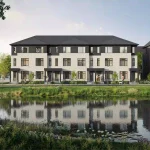 Waterfront view of modern three-story townhouses reflected in a scenic pond at Cornerstone.