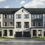 Front view of Traditional Towns at Reva Westfield, Brampton, showcasing white brick exteriors, integrated ground-floor garages, and contemporary architectural design with stone detailing.