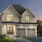 Exterior view of the 36-foot Starport A model at Homestead Meadows, a stately light stone home with two prominent gables, a double-car garage, and elegant front entryway lighting.