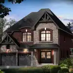 Exterior view of a 36-foot detached luxury home in Sharon Village, highlighting a mixed brick and stone exterior, a double-car garage, and a covered front entryway under a dramatic peaked roofline.