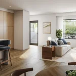 Open-concept modern interior of a Spruce Trails home featuring a kitchen island with seating, hardwood flooring, and a sunlit living room facing outdoor green space.