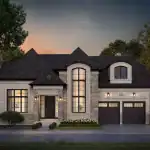 Exterior front view of a luxury custom home in The Legacy, showcasing a stone and light brick facade, dark gabled rooflines, a tall arched window, and a two-car garage at dusk.