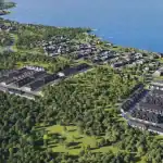 High-angle aerial rendering of Wasaga Walk community, showing modern townhouse clusters nestled among lush green trees near the blue waters of the Georgian Bay coastline.