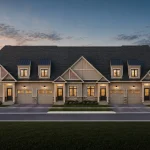 Exterior rendering of a row of bungaloft townhouses at Harwood Place, showcasing a classic design with beige board-and-batten siding, pitched gables, dormer windows, and attached garages.