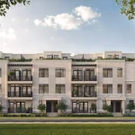 Modern multi-story townhome exterior at South Banks Elevation C featuring light stone masonry, black framed windows, and rooftop terraces.