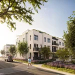 Streetscape view of modern light beige multi-story townhouse buildings at the South Banks community with a person jogging along the sidewalk