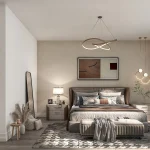 Spacious master bedroom suite at Bayview Green styled in warm neutral tones with a king-sized bed, decorative lighting, and adjacent ensuite bath entrance.