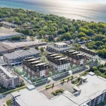 High-angle aerial rendering of the Kerr Village Towns development showing townhouse blocks near the waterfront and surrounding greenery