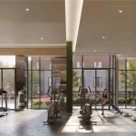 Fully equipped fitness centre at Merrydale Residences at Thornhill Walk featuring stationary bikes, treadmills, ellipticals, and a yoga stretching studio area with floor-to-ceiling windows.