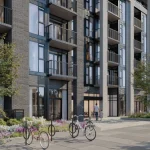 Street-level view of Merrydale Residences at Thornhill Walk showing pedestrian walkway, ground-floor amenities, bicycle parking, and outdoor seating area.