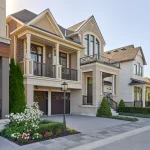 Modern two-story stone and brick homes with upper balconies, paved driveways, and landscaped gardens in the Preserve North community by Mattamy Homes