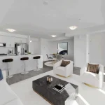 Open-concept living room, kitchen, and dining area at Countryside Urban Towns featuring modern furniture and an island with barstool seating.