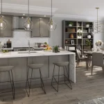 Modern open-concept kitchen and dining room in The Taylor model at Lyric by Lynde Creek with a waterfall island, pendant lights, taupe cabinetry, and large windows.
