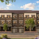 Exterior view of traditional three-story brick townhouses in the King Collection at Bond Townhomes with private garages and front entrances