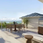 Private rooftop terrace at The Breakers with a hot tub, lounge chairs, outdoor dining set, grill, and panoramic ocean views.